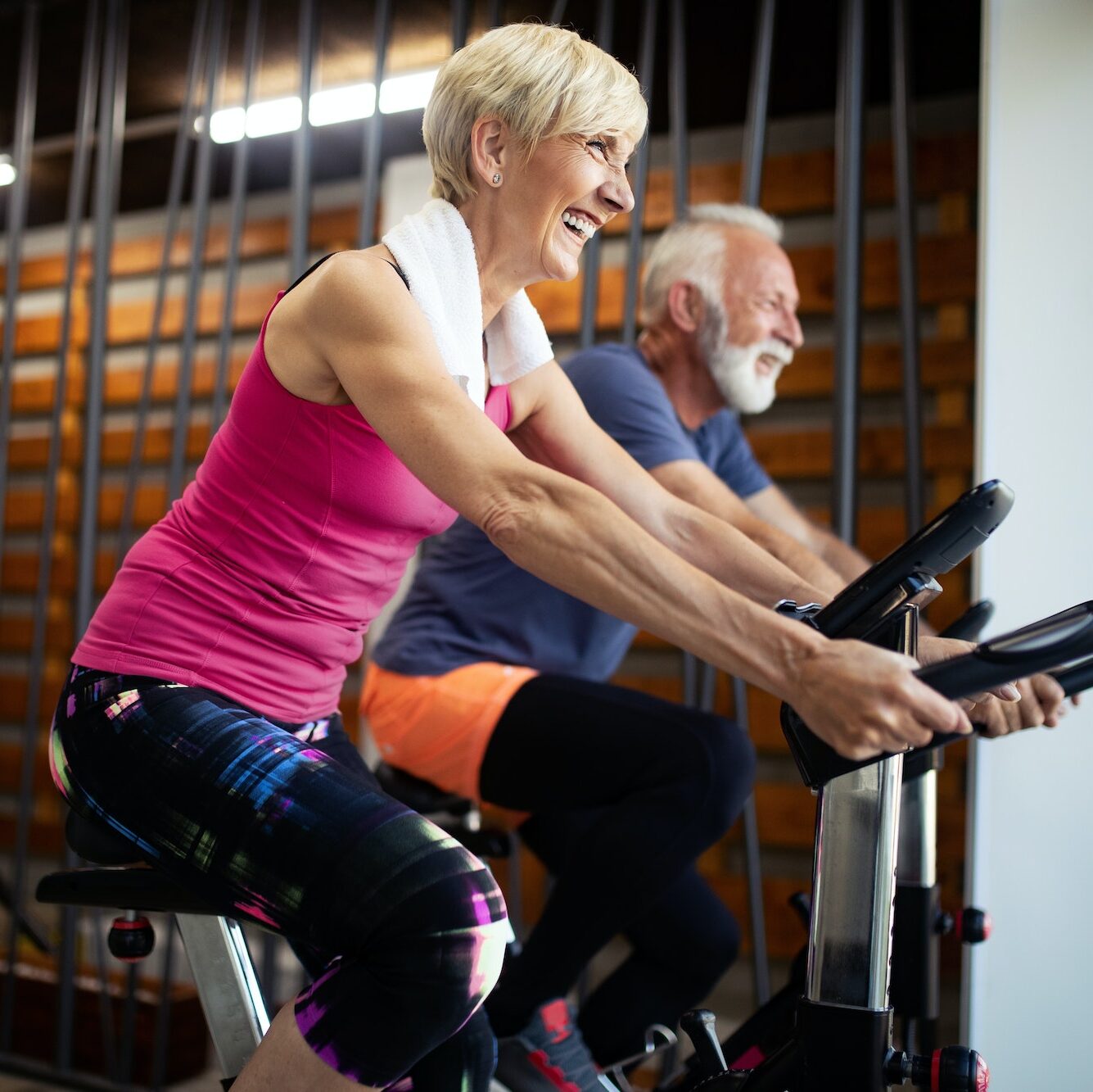Happy senior people doing indoor biking in a fitness club